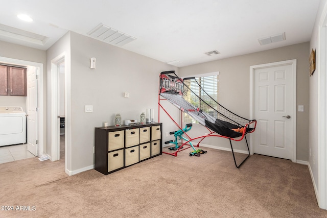 playroom featuring washer / dryer and light colored carpet