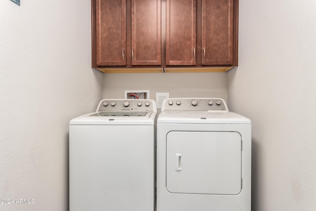 washroom featuring separate washer and dryer and cabinets