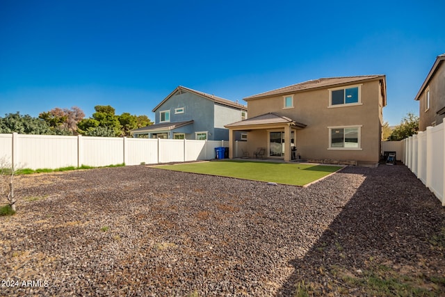 rear view of property featuring a yard and a patio area