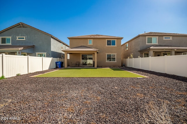 rear view of house with a patio and a lawn