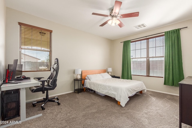 carpeted bedroom featuring ceiling fan and multiple windows