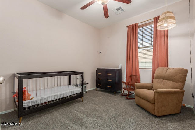 bedroom with a crib, carpet flooring, and ceiling fan