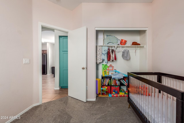 bedroom featuring a closet, carpet flooring, and a nursery area