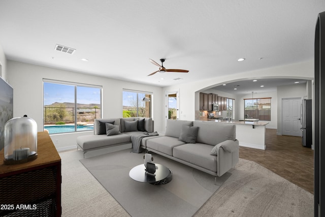 31221 N 130th Ln, Peoria, AZ 85383 - living room featuring plenty of natural light, recessed lighting, arched walkways, a ceiling fan, and baseboards
