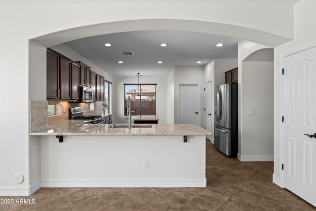 31221 N 130th Ln, Peoria, AZ 85383 - kitchen with appliances with stainless steel finishes, arched walkways, a peninsula, dark brown cabinets, and recessed lighting