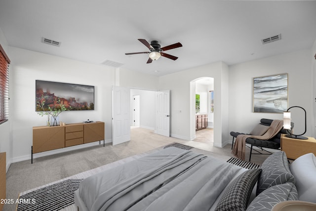31221 N 130th Ln, Peoria, AZ 85383 - bedroom with arched walkways, light carpet, baseboards, ceiling fan, and ensuite bathroom