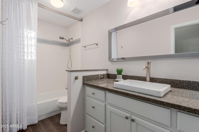 full bathroom featuring visible vents, toilet, wood tiled floor, shower / tub combo, and vanity