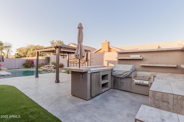 view of patio with grilling area, an outdoor kitchen, a fenced backyard, and a fenced in pool