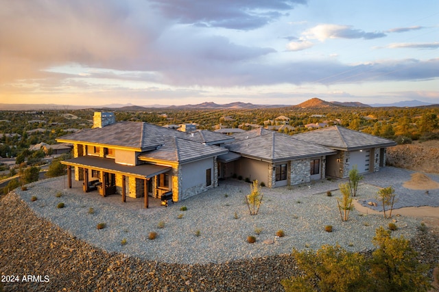 back house at dusk featuring a mountain view