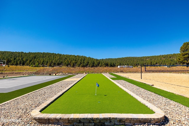 view of home's community featuring basketball hoop and volleyball court