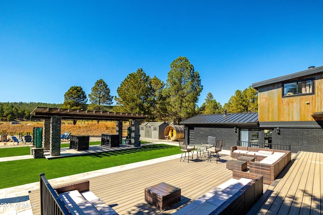 wooden deck featuring a yard, an outdoor living space with a fire pit, and a storage shed