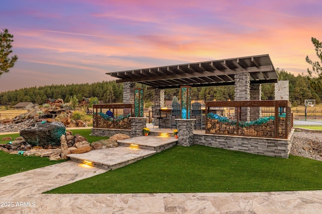 patio terrace at dusk featuring a yard