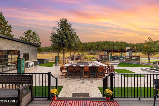 patio terrace at dusk featuring an outdoor bar