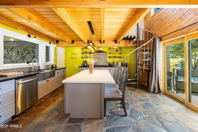 kitchen featuring decorative light fixtures, white cabinets, a center island, stainless steel dishwasher, and wood ceiling