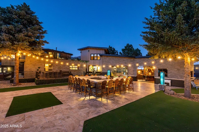 patio at night featuring an outdoor bar