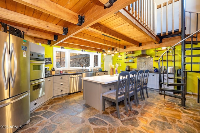 kitchen with wood ceiling, appliances with stainless steel finishes, a kitchen island, and white cabinets