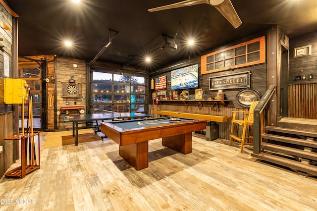 rec room with pool table, wooden walls, and light hardwood / wood-style floors