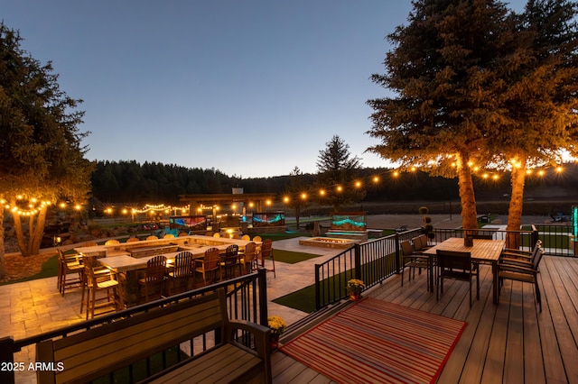 deck at dusk featuring a pool