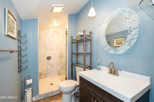 bathroom featuring an enclosed shower, vanity, hardwood / wood-style flooring, and toilet