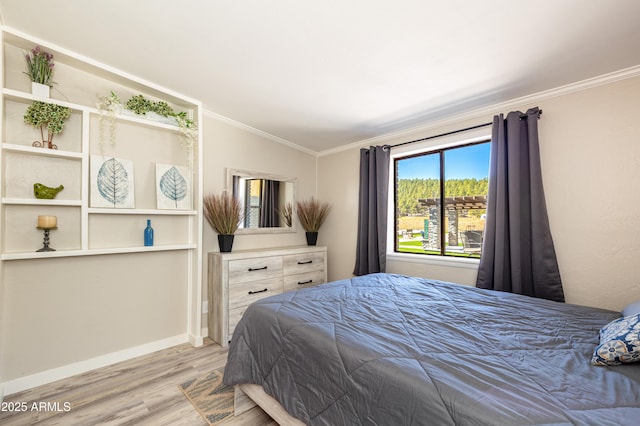 bedroom featuring ornamental molding, vaulted ceiling, and light wood-type flooring