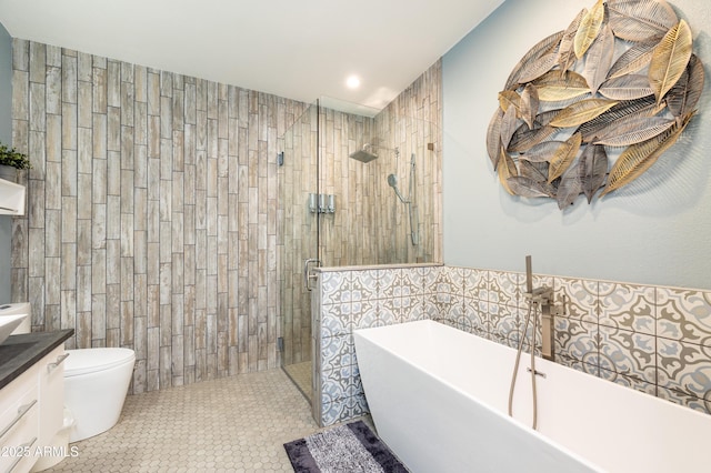 full bathroom featuring shower with separate bathtub, tile walls, tile patterned flooring, vanity, and toilet