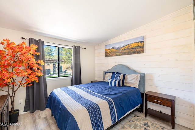 bedroom with wood-type flooring and wood walls