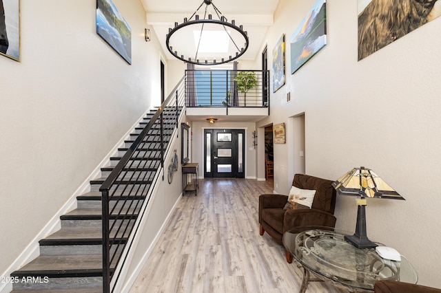 entryway with an inviting chandelier, hardwood / wood-style floors, and a high ceiling