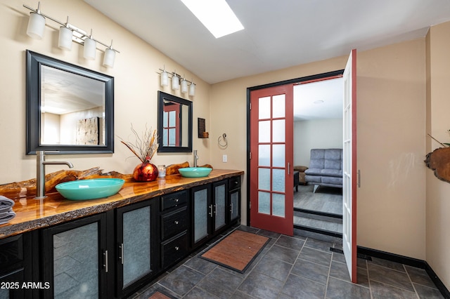 bathroom featuring vanity, a skylight, and french doors