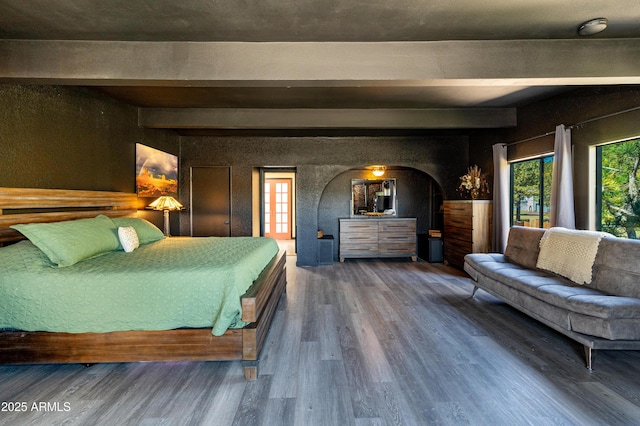 bedroom featuring hardwood / wood-style floors and beam ceiling