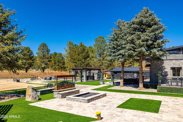 view of community with a gazebo, a fire pit, a lawn, and a patio