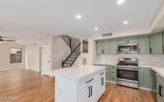 20929 N 37th Way, Phoenix, AZ 85050 - kitchen featuring green cabinetry, appliances with stainless steel finishes, light countertops, backsplash, and light wood-type flooring