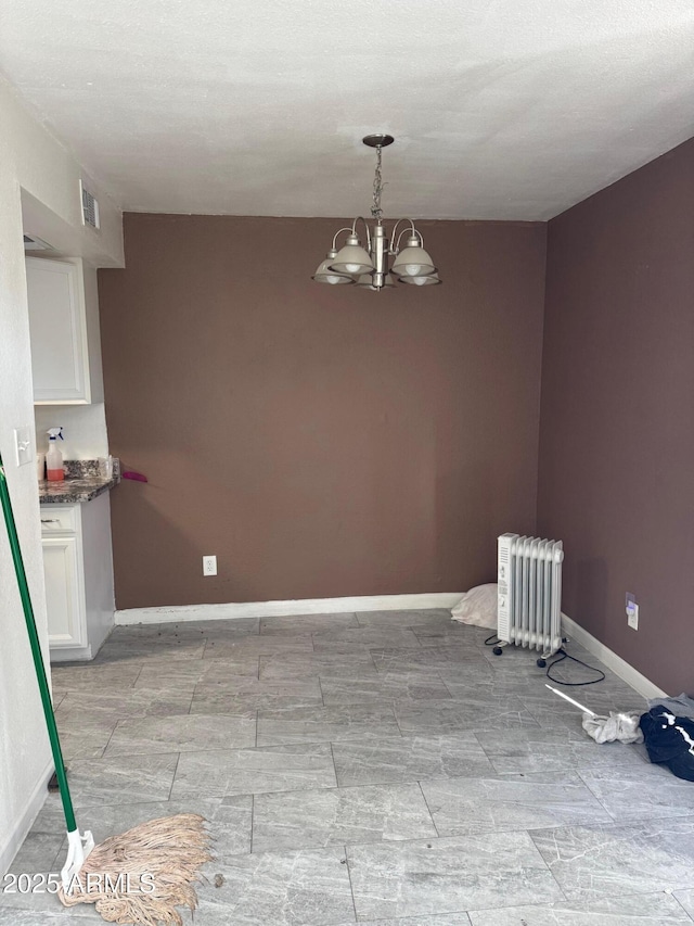 unfurnished dining area with a notable chandelier, baseboards, visible vents, and radiator