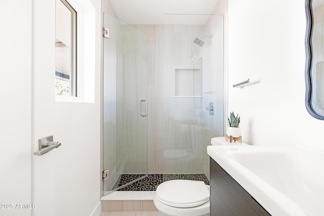 bathroom with an enclosed shower, vanity, and toilet