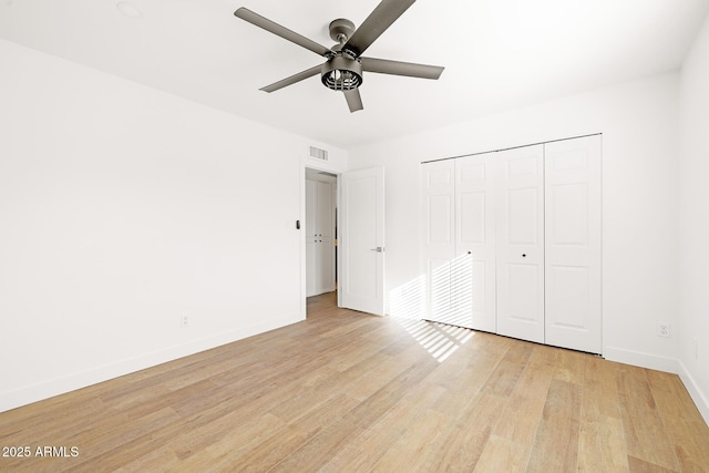 unfurnished bedroom with ceiling fan, a closet, and light wood-type flooring