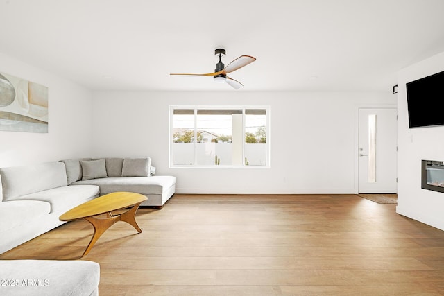 living room featuring ceiling fan and light wood-type flooring