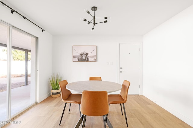 dining space featuring light hardwood / wood-style floors and a chandelier