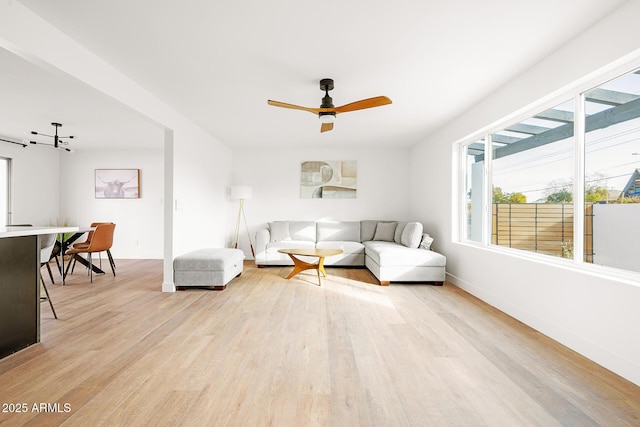 living room featuring ceiling fan and light hardwood / wood-style floors