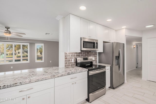 kitchen featuring white cabinetry, ceiling fan, stainless steel appliances, light stone counters, and backsplash