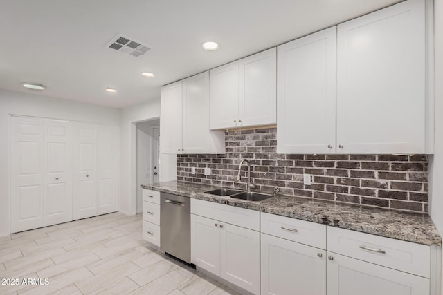 kitchen with white cabinets, dishwasher, dark stone countertops, and sink