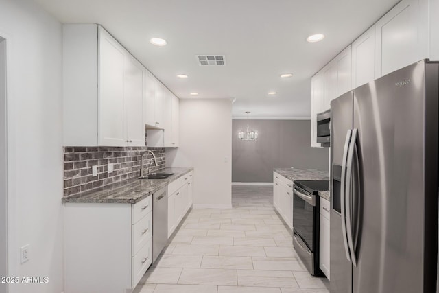 kitchen with stainless steel appliances, sink, pendant lighting, dark stone countertops, and white cabinets