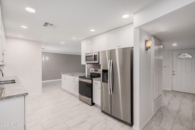 kitchen with white cabinets, sink, stainless steel appliances, and tasteful backsplash