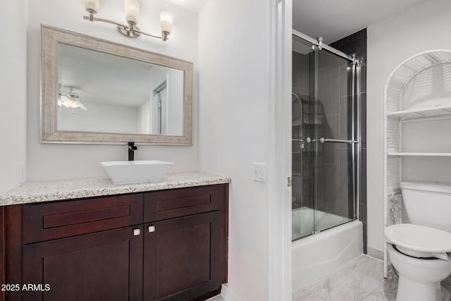 full bathroom featuring combined bath / shower with glass door, ceiling fan, toilet, and vanity