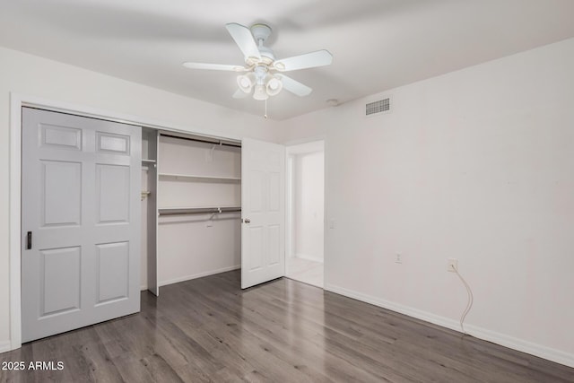 unfurnished bedroom with ceiling fan, wood-type flooring, and a closet