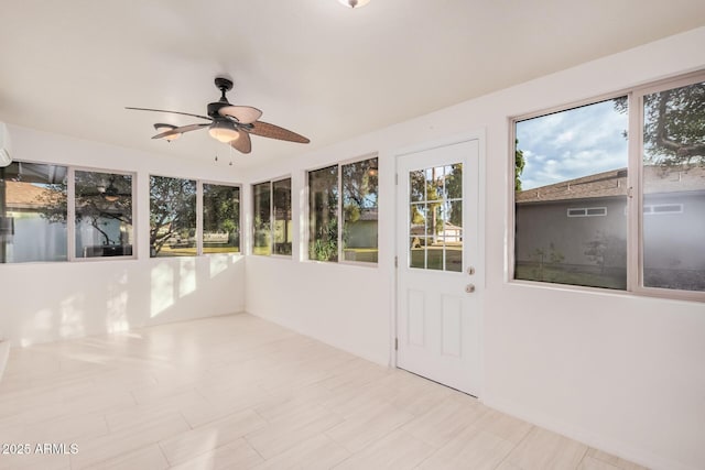 unfurnished sunroom featuring ceiling fan