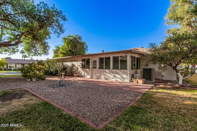 rear view of house featuring a lawn, a patio area, and central AC unit