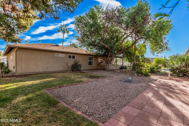 rear view of property with a yard and a patio