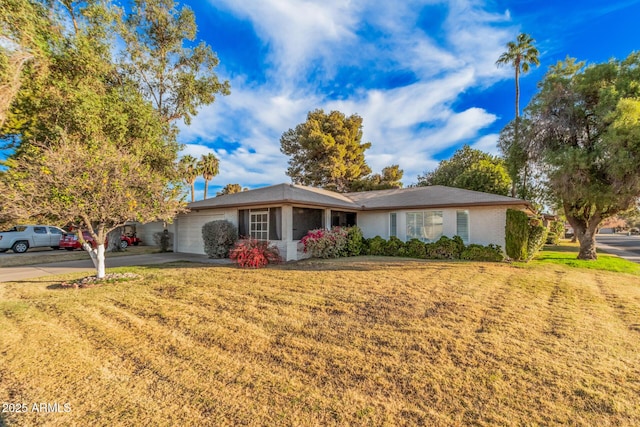 ranch-style house featuring a front lawn and a garage