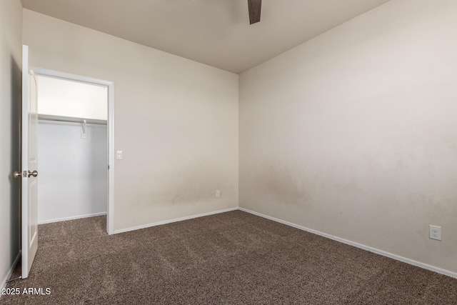 unfurnished bedroom with ceiling fan, a closet, and dark carpet