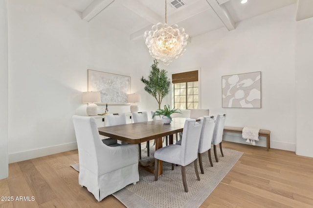 dining area with beam ceiling, a notable chandelier, coffered ceiling, and light hardwood / wood-style floors