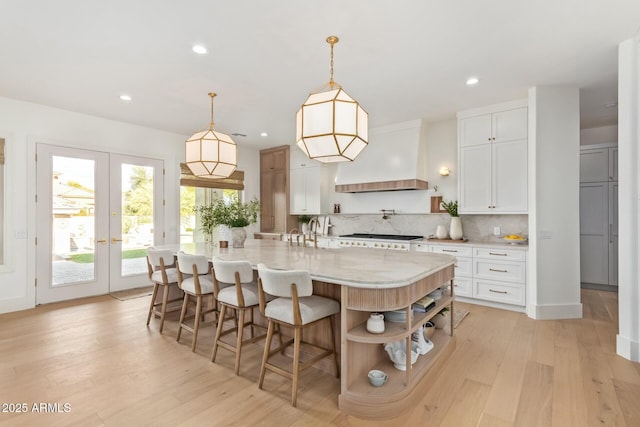 kitchen with white cabinetry, pendant lighting, decorative backsplash, and a spacious island